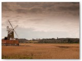 Windmill on the horizon under a brown sky